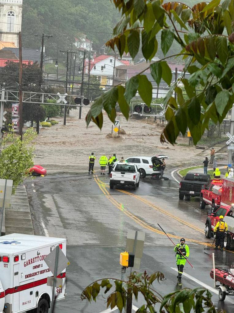 Road flooded image with emergency response vehicles shown helping.